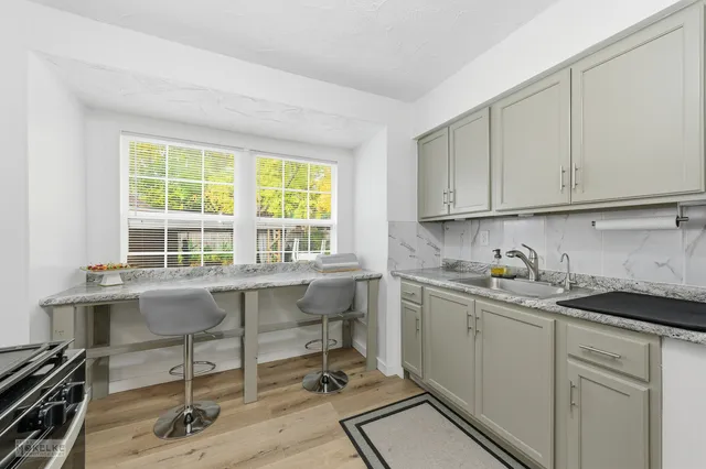a kitchen with a sink a window and cabinets