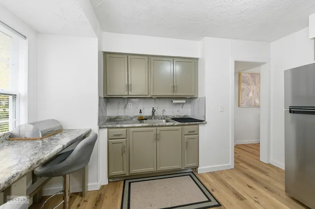 a kitchen with stainless steel appliances granite countertop a stove refrigerator sink and microwave