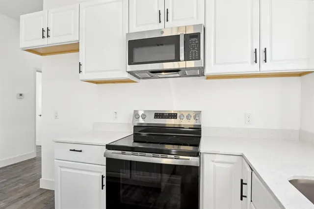a kitchen with stainless steel appliances a stove and a microwave