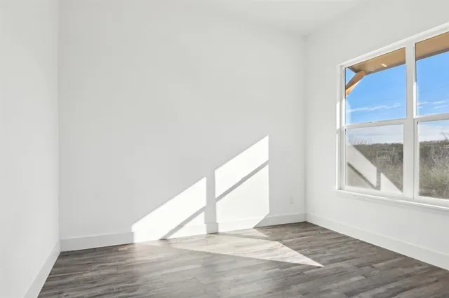 a view of a hallway with wooden floor and closet