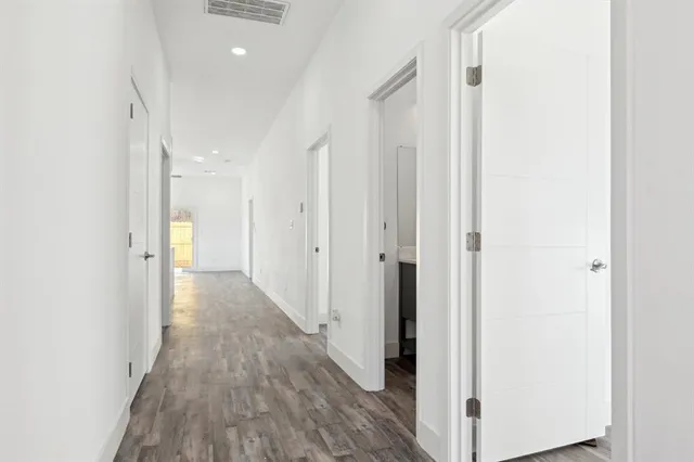 a view of a hallway with wooden floor
