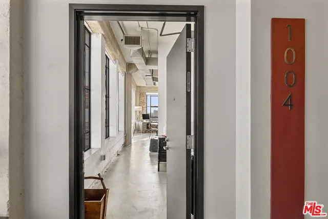 a spacious bedroom with a bed and wooden floor