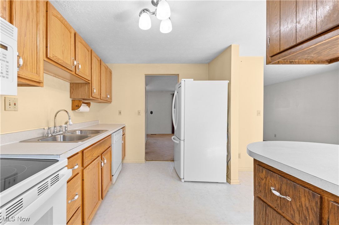 4301 Baird Road Stow, OH 44224 - Photo 14 of 50 Kitchen featuring a sink, white appliances, light floors, light countertops, and baseboards