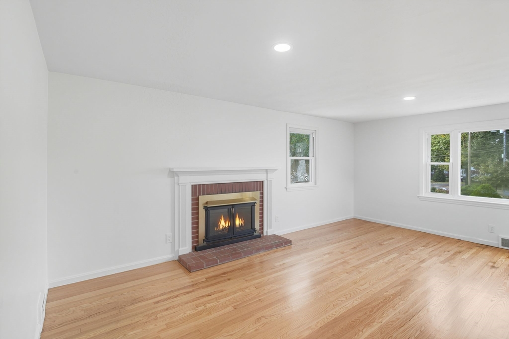 11 Copeland Street Springfield, MA 01108 - Photo 6 of 27 an empty room with wooden floor a fireplace and windows