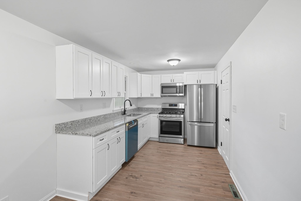 11 Copeland Street Springfield, MA 01108 - Photo 9 of 27 a kitchen with a sink a refrigerator and cabinets