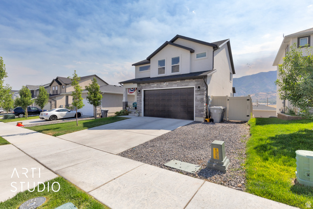 1713 South Windemere Road Santaquin, UT 84655 - Photo 2 of 40 Contemporary two-story residence featuring a dark garage door, stone facade accents, and a light-toned exterior