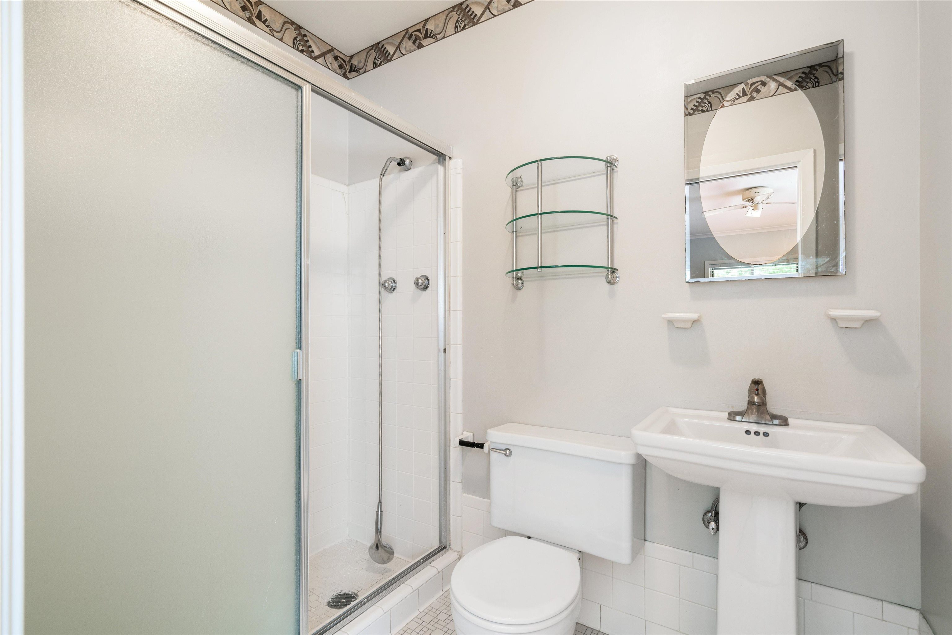 5670 North Angela Road Memphis, TN 38120 - Photo 19 of 22 a bathroom with a sink a mirror a toilet and shower