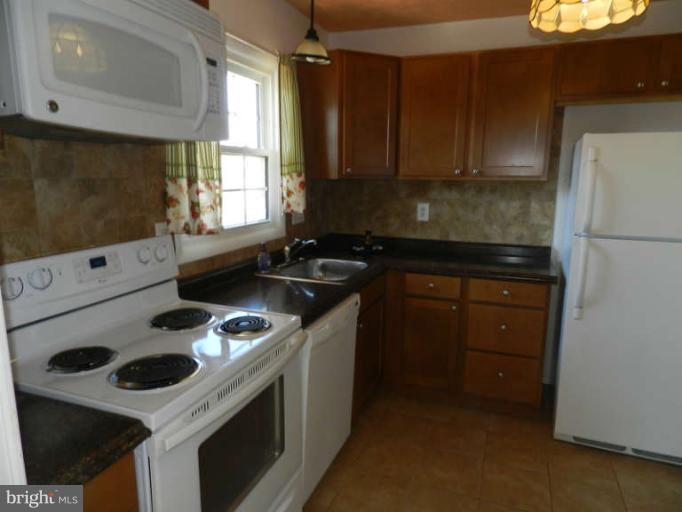 1849 Montreal Road Severn, MD 21144 - Photo 4 of 23 a kitchen with a stove a sink and a microwave