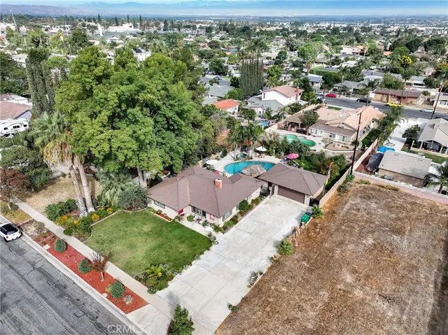 a aerial view of a house with a yard and a large tree