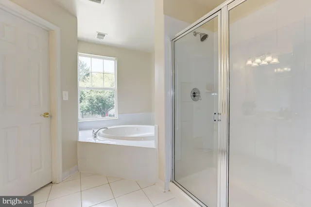 a bathroom with a bathtub a shower and a sink