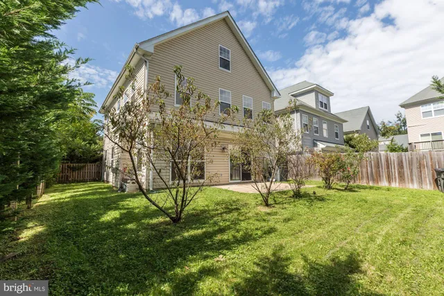 a view of a big house with a big yard and large trees