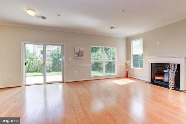 an empty room with wooden floor and a fireplace