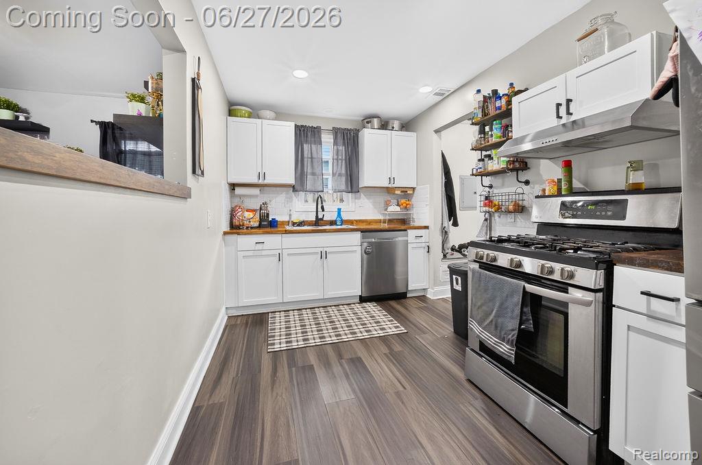 7715 Beech Daly Road Taylor, MI 48180 - Photo 12 of 21 Kitchen featuring wood-finish flooring, white cabinetry, light wood-finish countertops, stainless steel appliances, and a white subway tile backsplash