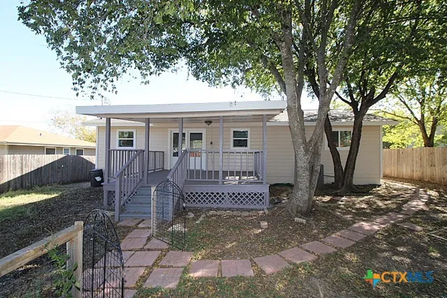 a view of a house with backyard and a tree