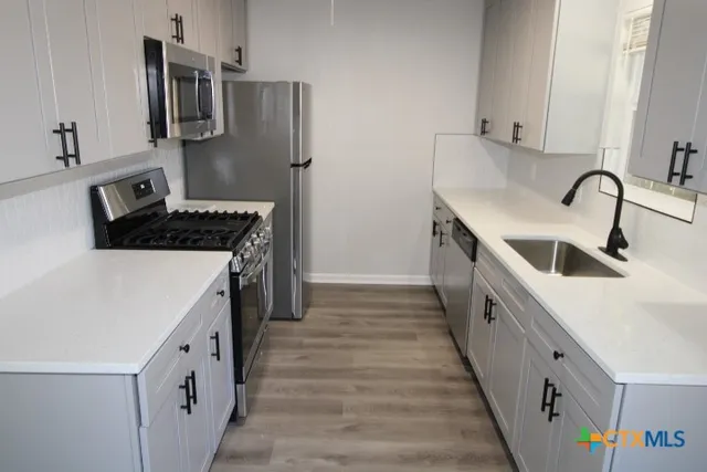 a kitchen with granite countertop a sink and a stove top oven