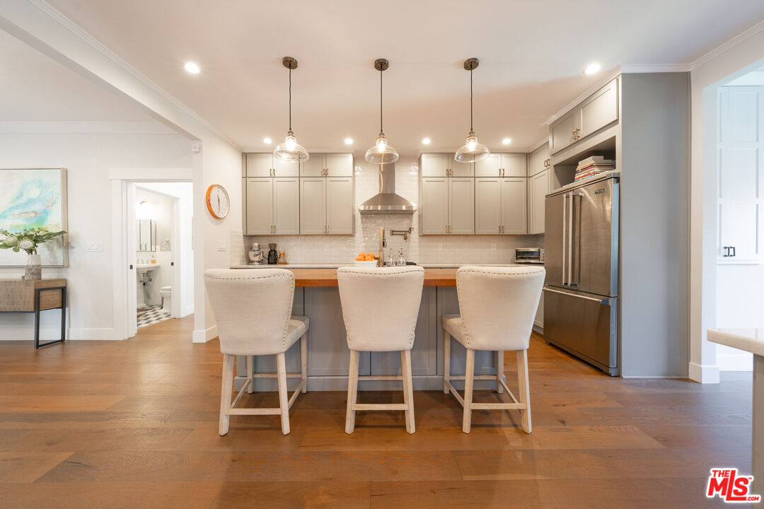 385 North Wilton Place Los Angeles, CA 90004 - Photo 17 of 53 a dining room with kitchen island stainless steel appliances furniture a chandelier and kitchen view