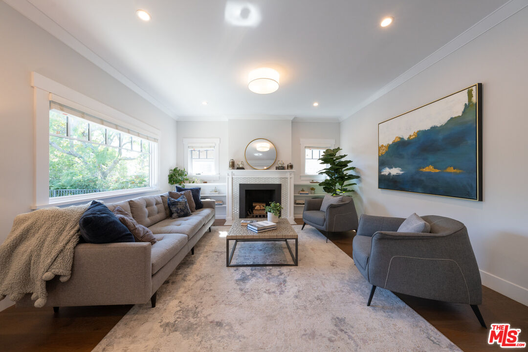385 North Wilton Place Los Angeles, CA 90004 - Photo 6 of 53 a living room with furniture a fireplace and a flat screen tv