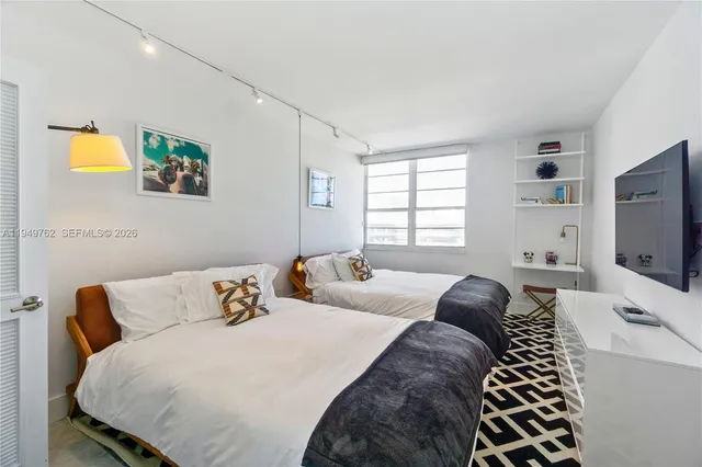 a bedroom with a bed and a flat screen tv