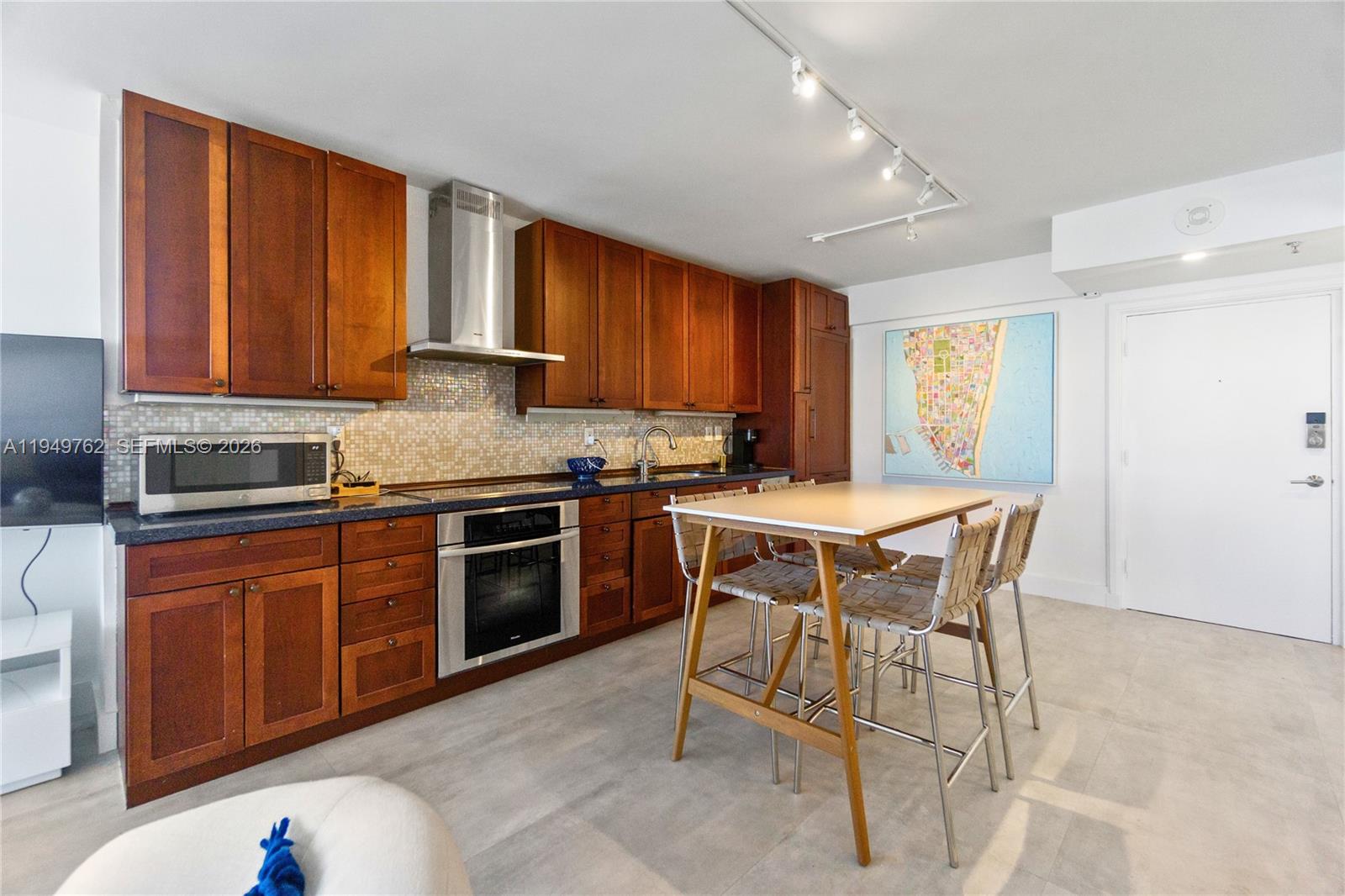 100 Lincoln Road, Unit 1447 Miami Beach, FL 33139 - Photo 7 of 39 a kitchen with stainless steel appliances granite countertop wooden cabinets a stove top oven a sink and dishwasher