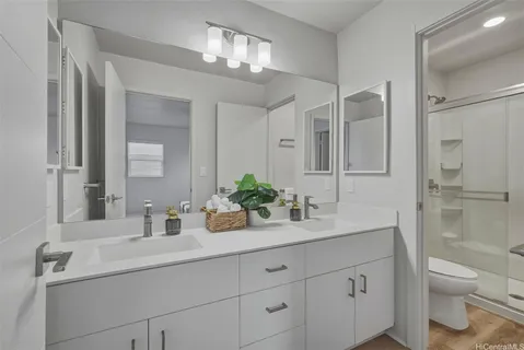a bathroom with a sink a toilet and shower