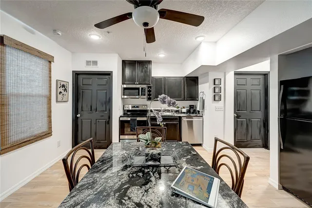 a kitchen with stainless steel appliances kitchen island granite countertop a stove refrigerator and cabinets