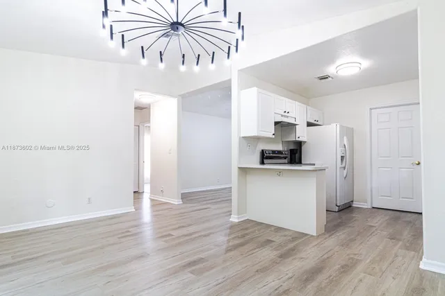 a kitchen with a refrigerator and a stove top oven