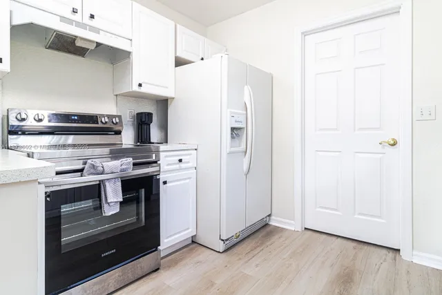 a kitchen with stainless steel appliances a stove a microwave and a refrigerator