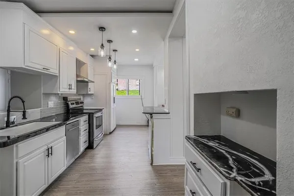 a kitchen with granite countertop a stove and a sink