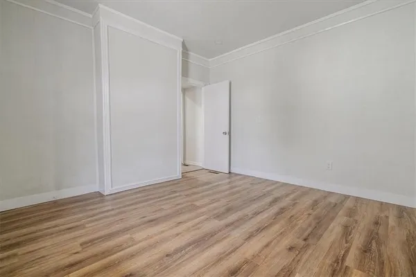 a view of an empty room with wooden floor