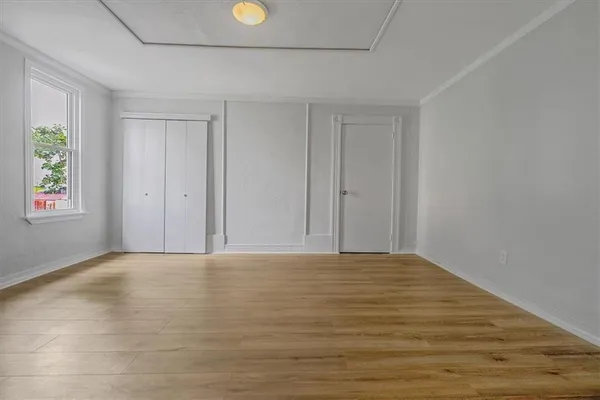a view of an empty room with window and closet area