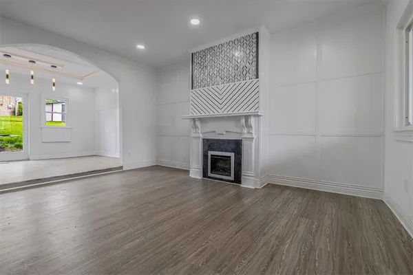 an empty room with wooden floor and a fireplace