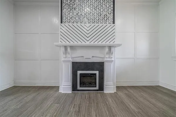 a view of a livingroom with wooden floor and a fireplace