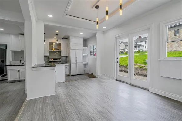 a view of a kitchen with refrigerator and wooden floor