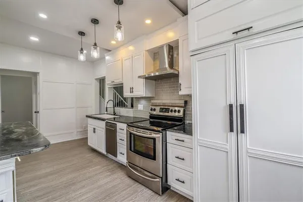 a kitchen with stainless steel appliances granite countertop a stove and a refrigerator