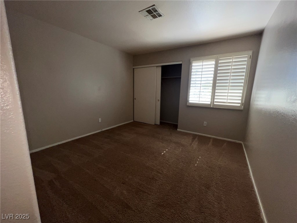 8028 Desire Drive Las Vegas, NV 89128 - Photo 15 of 15 Unfurnished bedroom featuring dark carpet and a closet