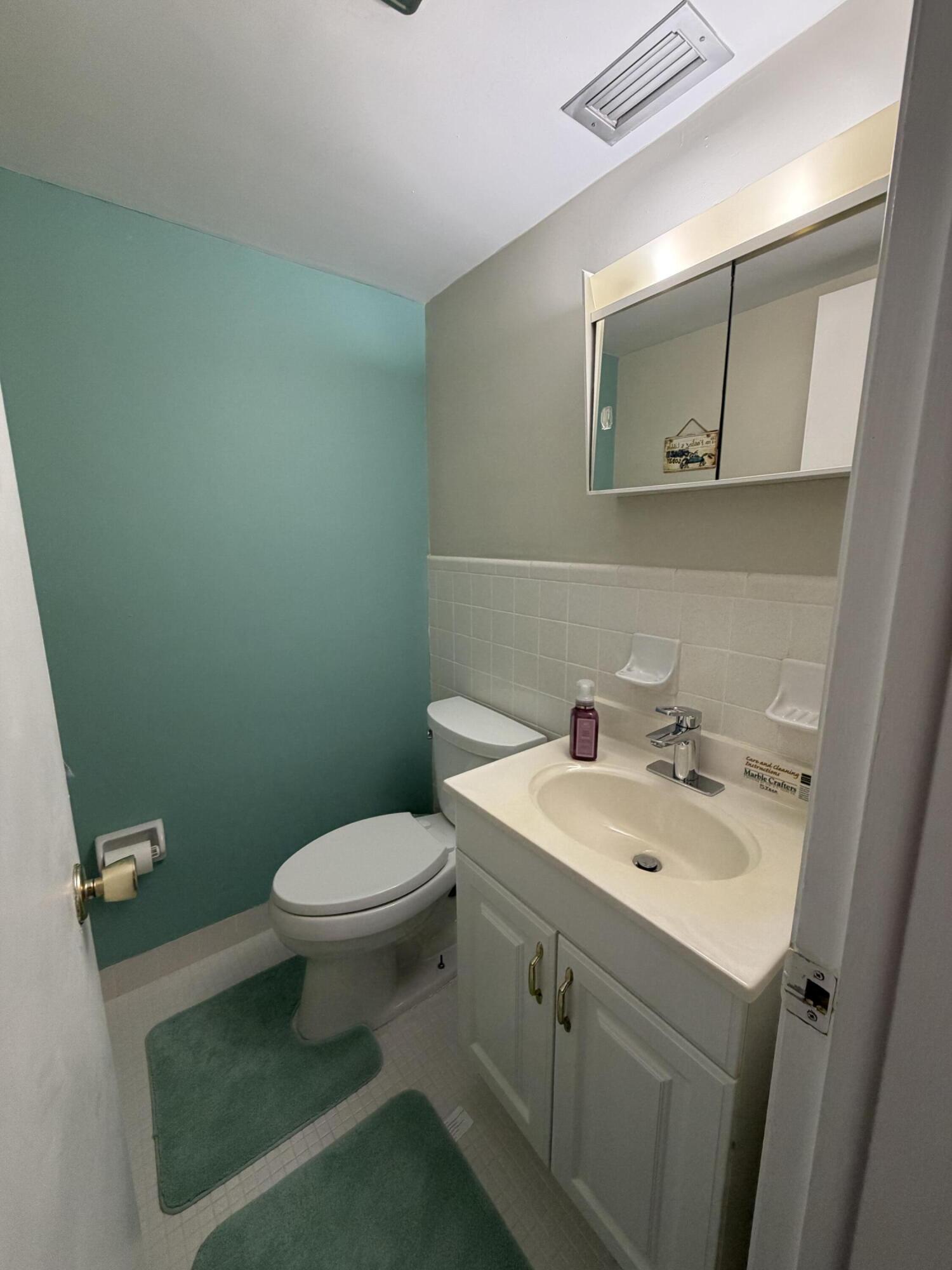 2050 Northeast 39th Street, Unit S103 Lighthouse Point, FL 33064 - Photo 11 of 46 a bathroom with a sink toilet and mirror