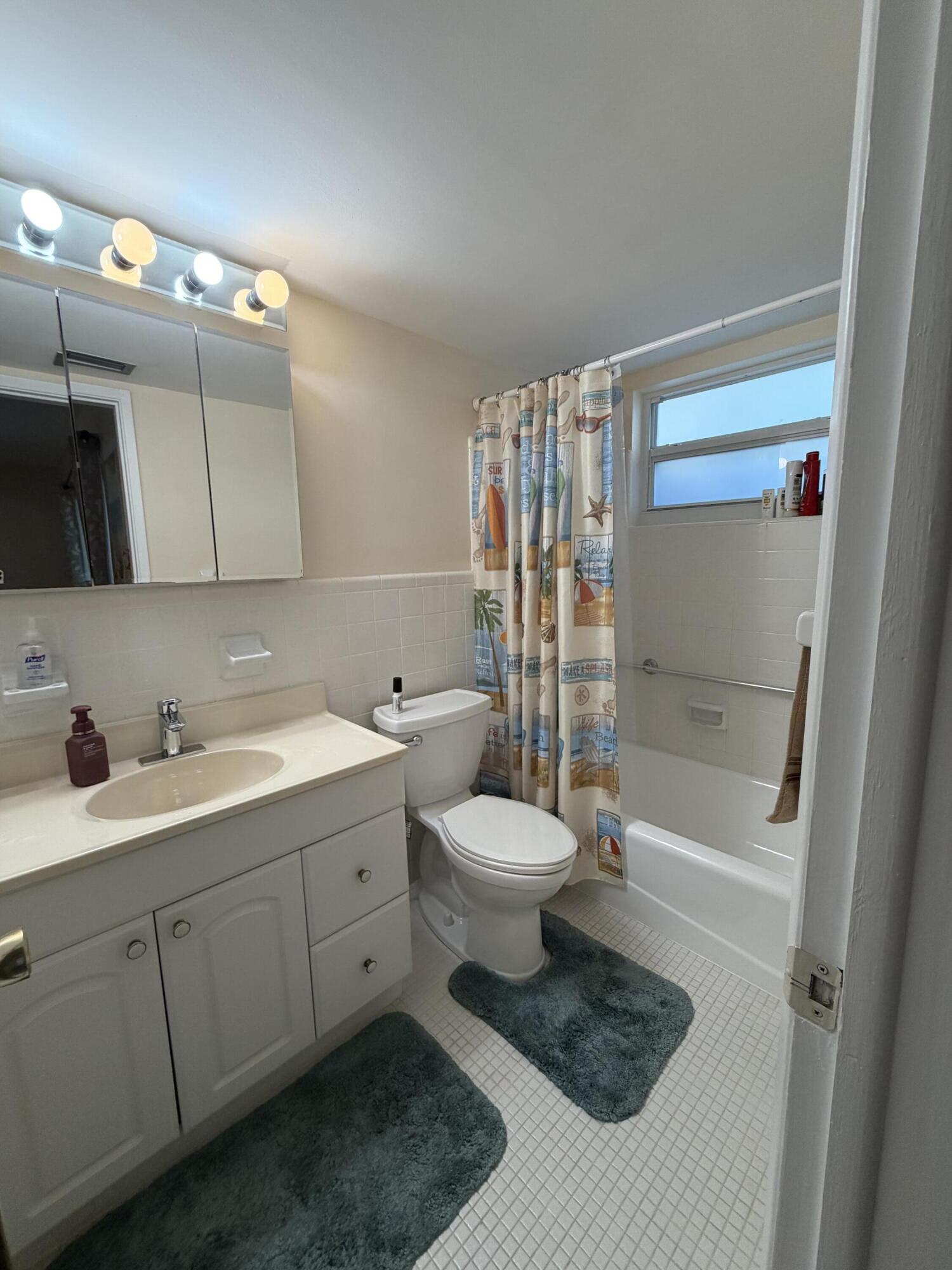 2050 Northeast 39th Street, Unit S103 Lighthouse Point, FL 33064 - Photo 18 of 46 a bathroom with a sink a toilet and shower