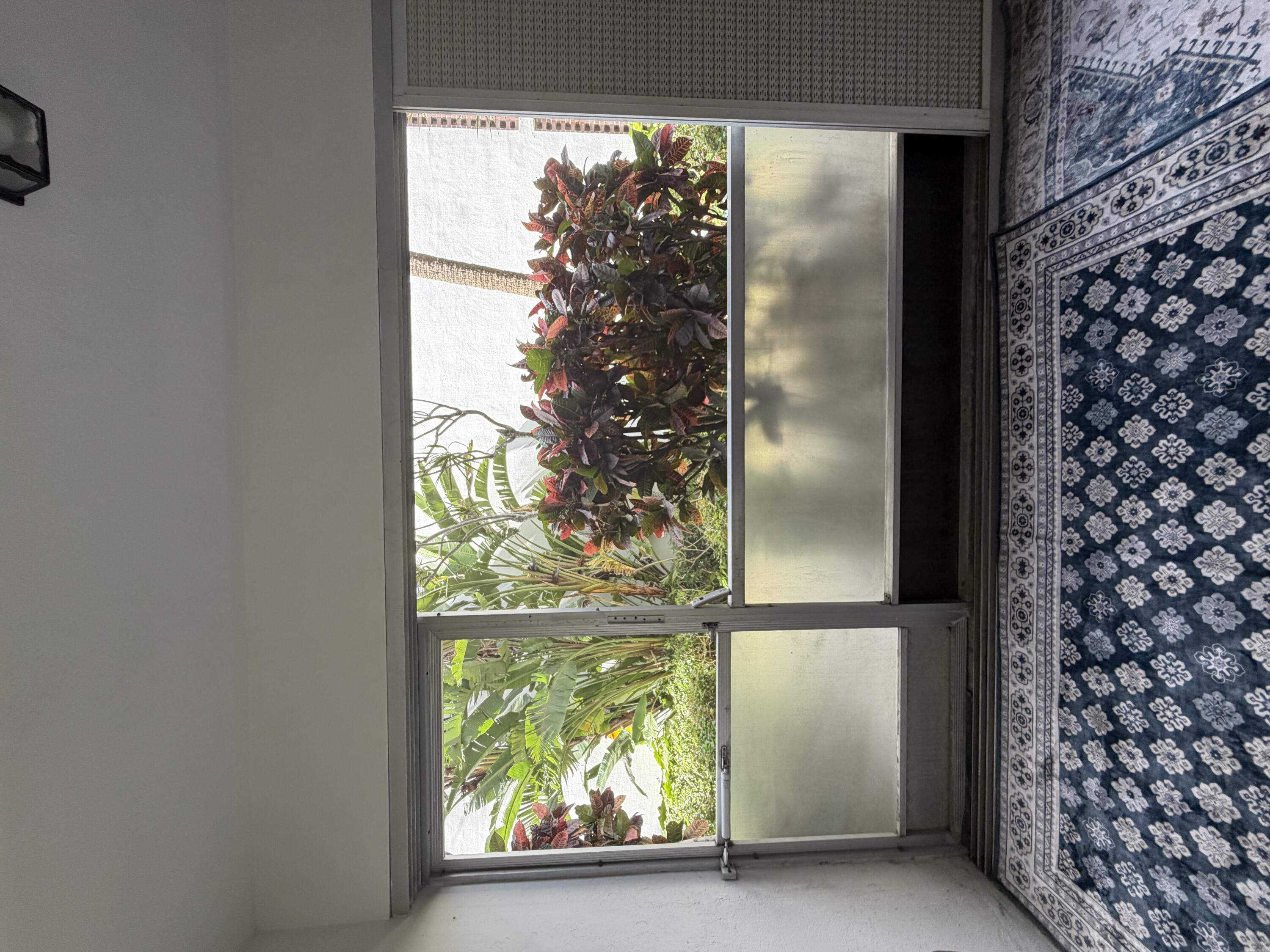 2050 Northeast 39th Street, Unit S103 Lighthouse Point, FL 33064 - Photo 24 of 46 a view of a glass door with a yard from inside of it