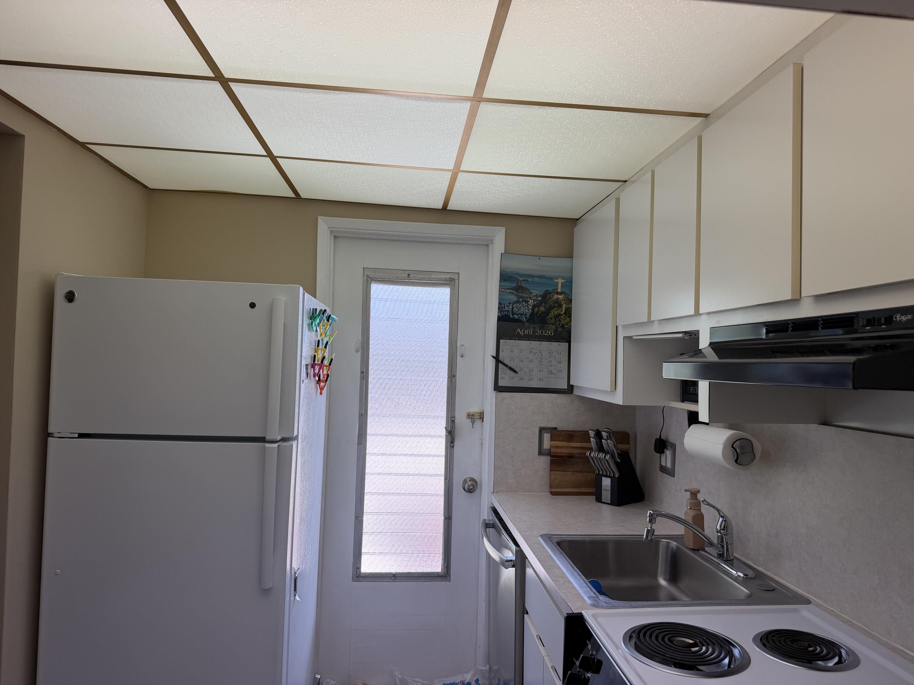 2050 Northeast 39th Street, Unit S103 Lighthouse Point, FL 33064 - Photo 26 of 46 a kitchen with a refrigerator and a sink