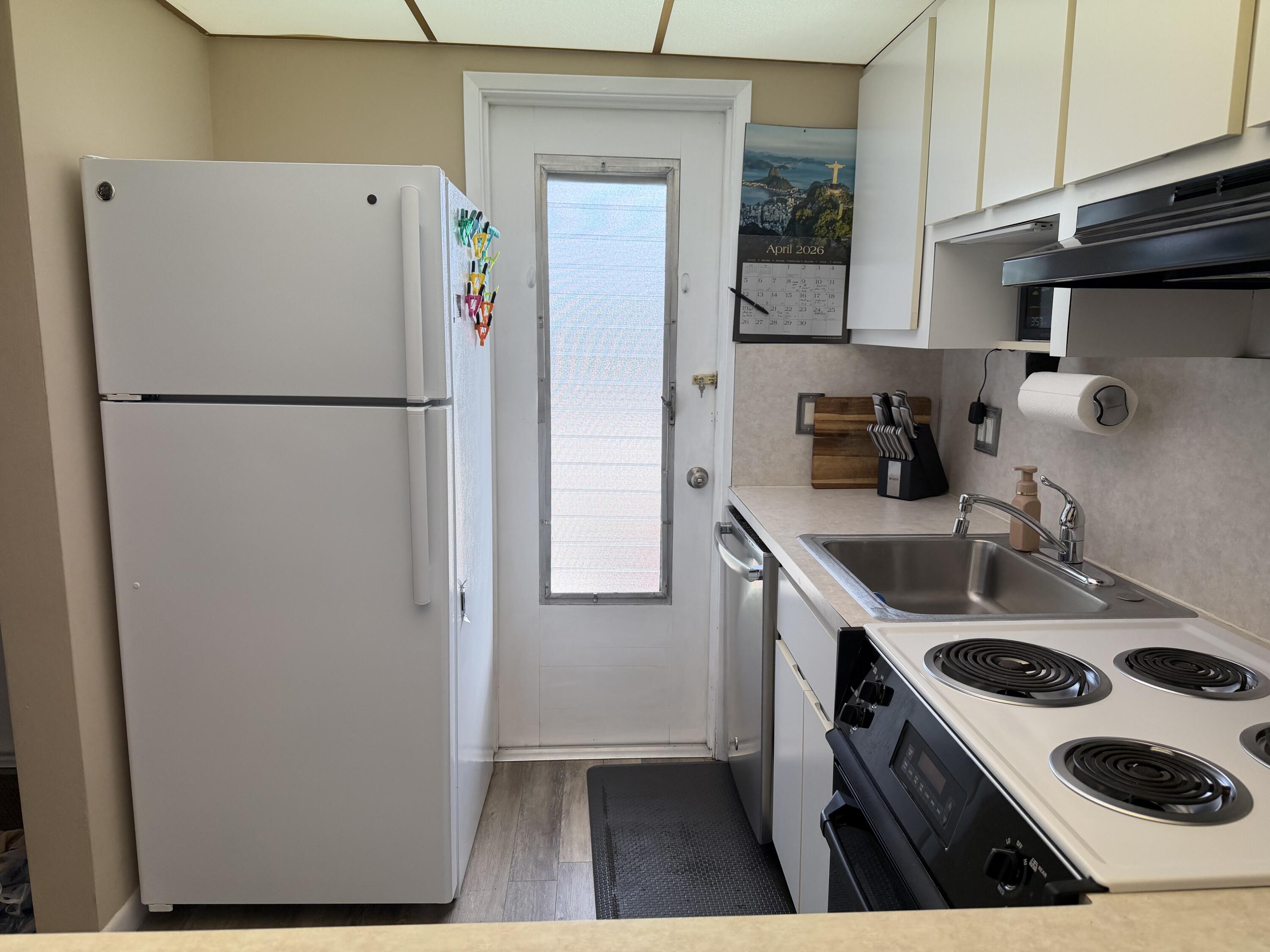 2050 Northeast 39th Street, Unit S103 Lighthouse Point, FL 33064 - Photo 28 of 46 a kitchen with a refrigerator and a sink