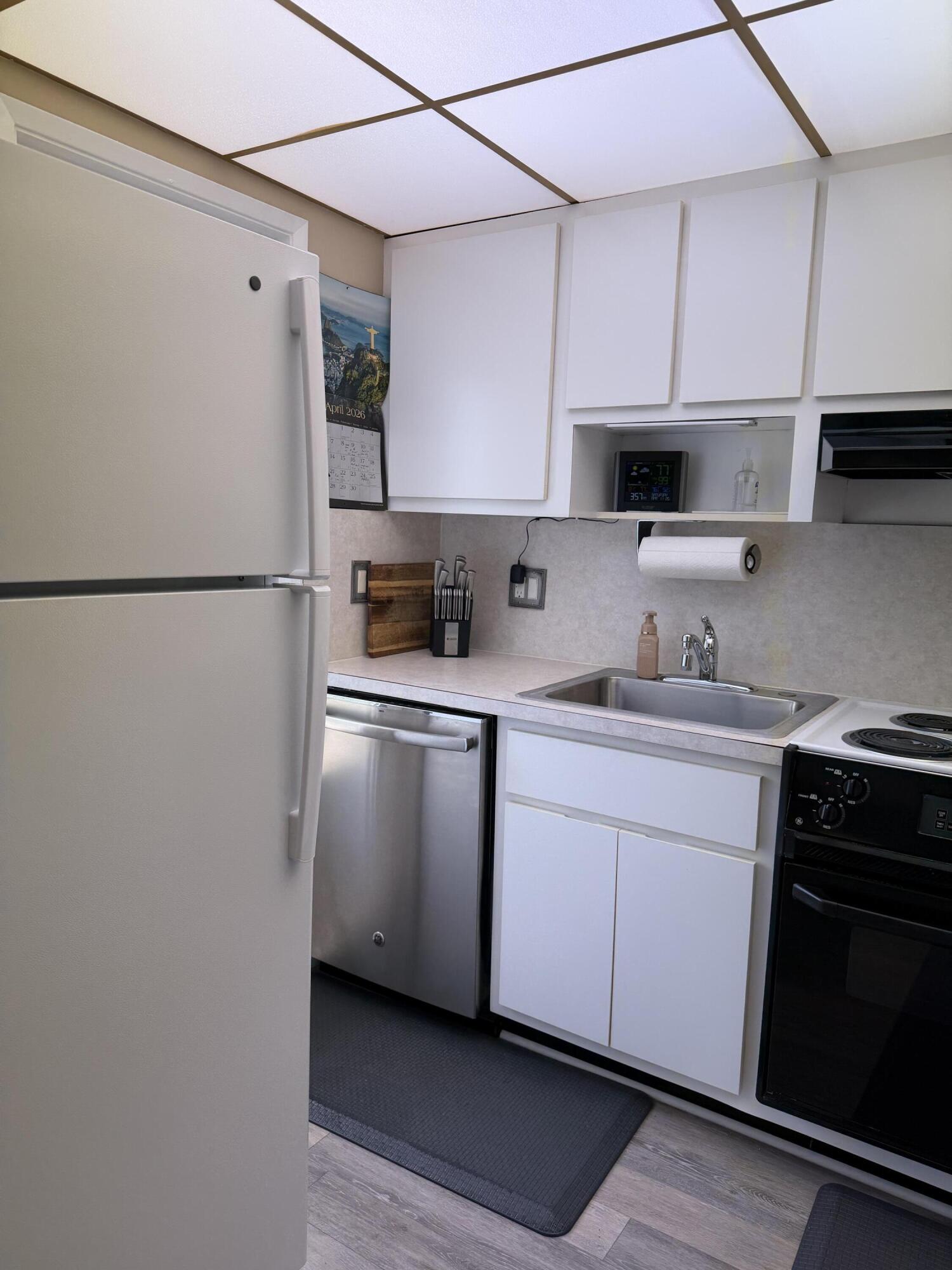 2050 Northeast 39th Street, Unit S103 Lighthouse Point, FL 33064 - Photo 44 of 46 a kitchen with stainless steel appliances a refrigerator sink and cabinets