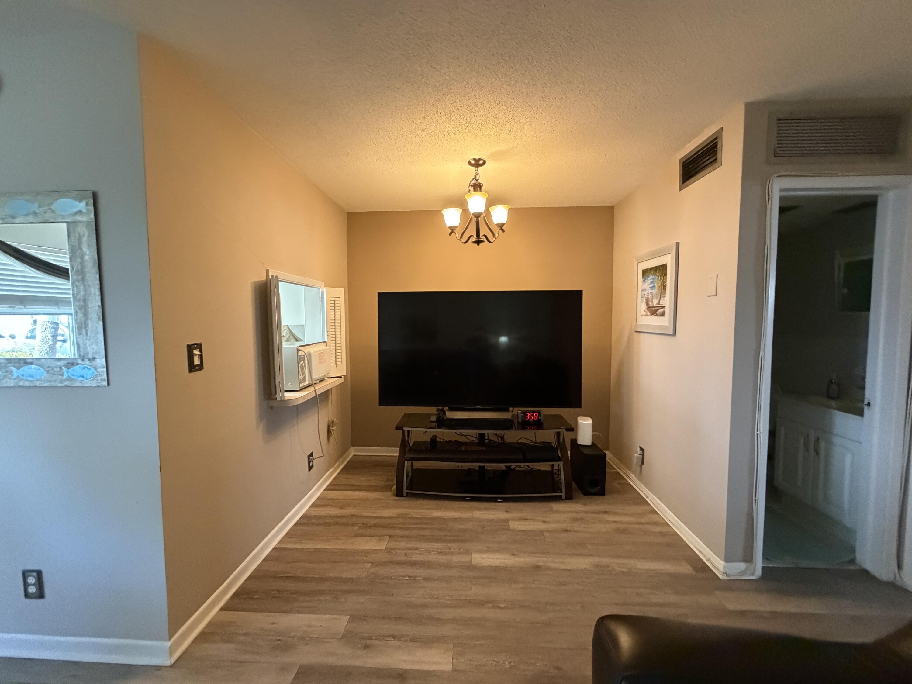 2050 Northeast 39th Street, Unit S103 Lighthouse Point, FL 33064 - Photo 9 of 46 a living room with furniture and a flat screen tv