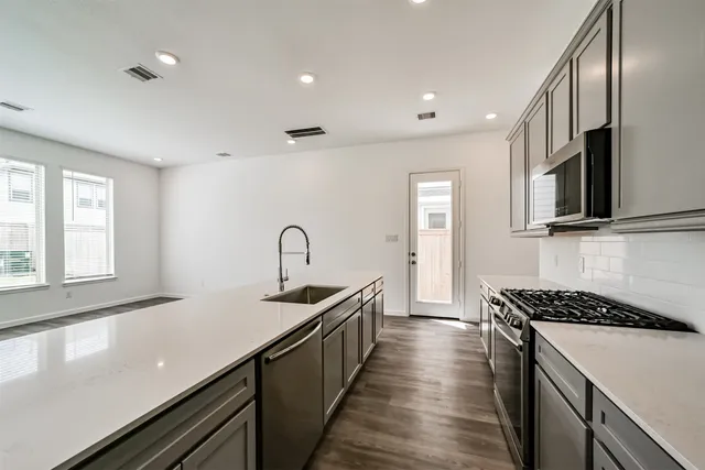 a kitchen with stainless steel appliances granite countertop a sink and a stove