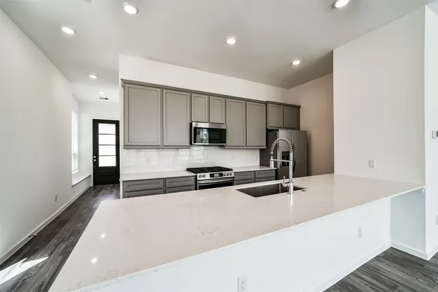 a view of kitchen with wooden floor and electronic appliances