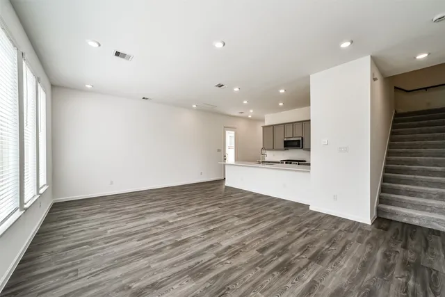 a large kitchen with stainless steel appliances kitchen island a large counter top a sink and a stove