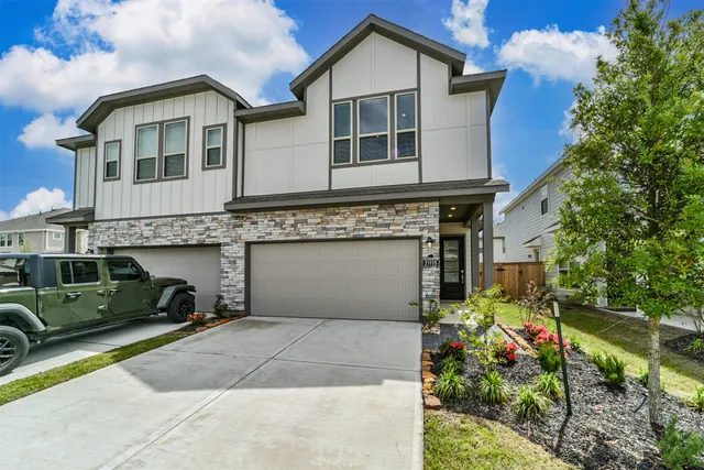 a front view of a house with a garden and plants