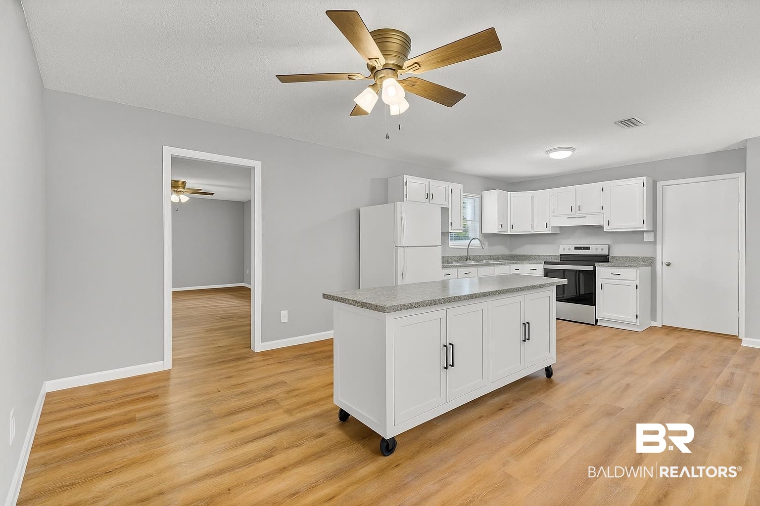 3304 Armond Drive Mobile, AL 36605 - Photo 15 of 62 Kitchen with stainless steel electric range oven, freestanding refrigerator, a ceiling fan, white cabinetry, and light wood-style floors