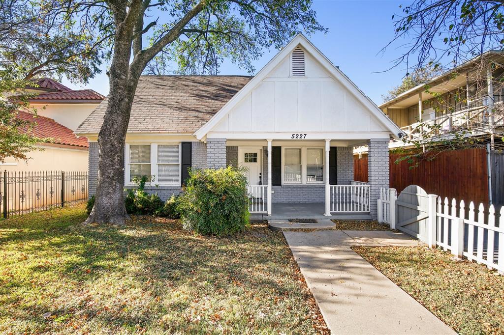 a view of a house with a small yard and wooden fence