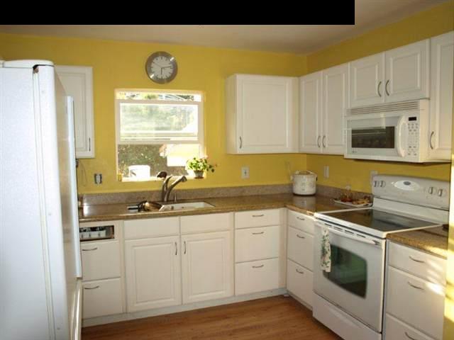 299 Awalau Road Haiku, HI 96708 - Photo 10 of 12 a kitchen with granite countertop white cabinets and white appliances
