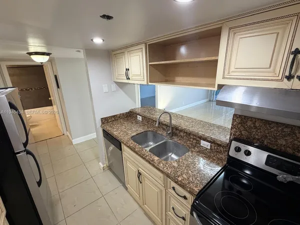 a kitchen with stainless steel appliances granite countertop a sink stove and cabinets